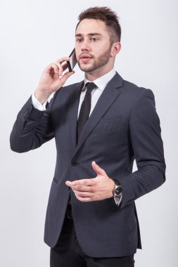 successful young student in a classic stylish suit talking on th