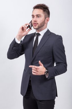 successful young student in a classic stylish suit talking on th