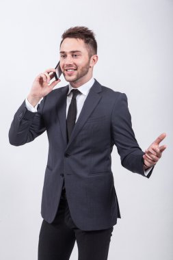 successful young student in a classic stylish suit talking on th