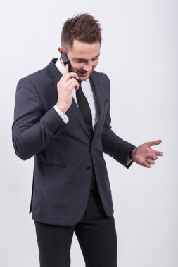 successful young student in a classic stylish suit talking on th