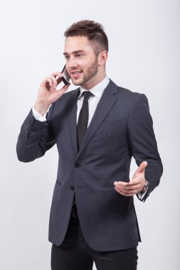 successful young businessman in classical stylish suit talking o