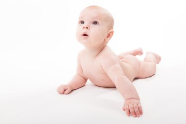 Midesi beyaz bir arka plan üzerinde yatan çıplak gülümseyen bebek bir