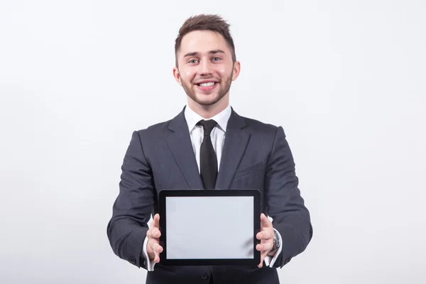 Joven empresario de éxito con una sonrisa en la cara muestra la — Foto de Stock