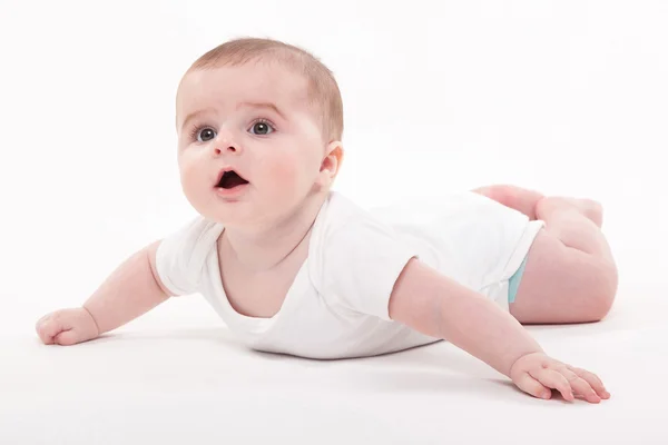 Dziecko w organizmie leżąc na brzuchu na białym tle i — Zdjęcie stockowe