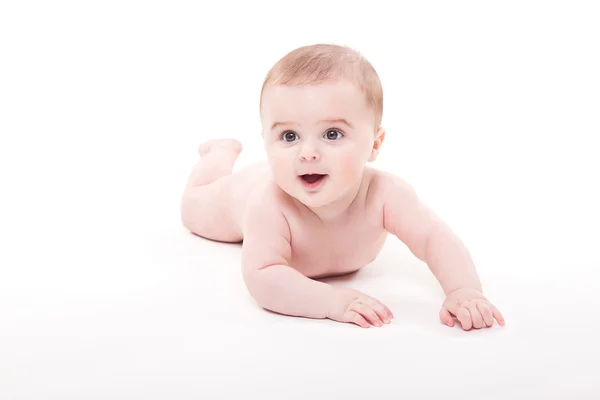 Naken smilende baby på magen på hvit bakgrunn en – stockfoto