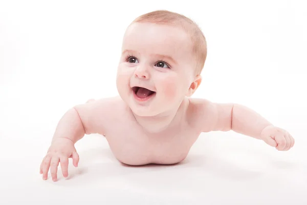 Naken smilende baby på magen på hvit bakgrunn en – stockfoto