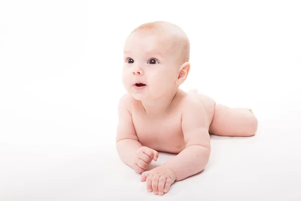 Nagi baby uśmiechający się leżąc na brzuchu na białym tle — Zdjęcie stockowe