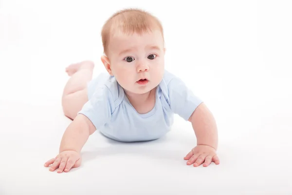 Dziecko w organizmie leżąc na brzuchu na białym tle i — Zdjęcie stockowe