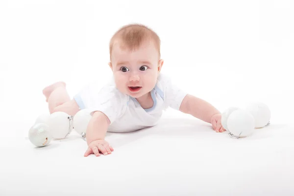 Baby on a white background playing with Christmas toys — Stock Photo, Image