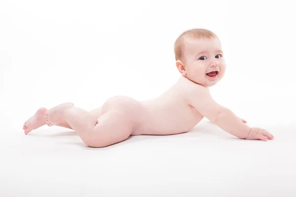 Naken smilende baby på magen på hvit bakgrunn en – stockfoto