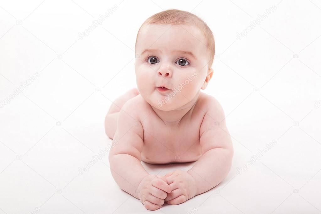 Naked smiling baby lying on his stomach on a white background an