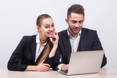 man and woman sitting in a business suit at a table in front of 
