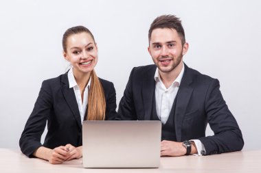 team of young business man and a woman sitting at computer and l clipart