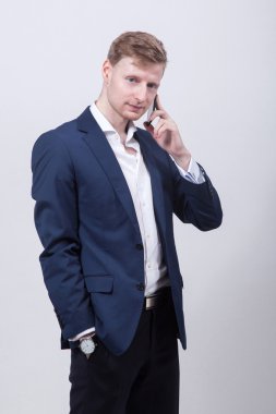 Genç öğrenci tal mavi ceket ve ayakta beyaz bir arka plan üzerinde