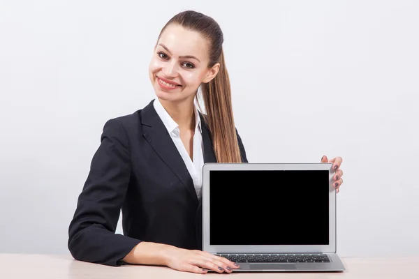 Beautiful modern business woman sitting at a table in front of a — Stock Photo, Image