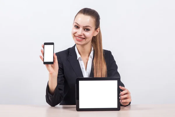 Elegante mujer de negocios joven en un traje de negocios sentado en un des — Foto de Stock