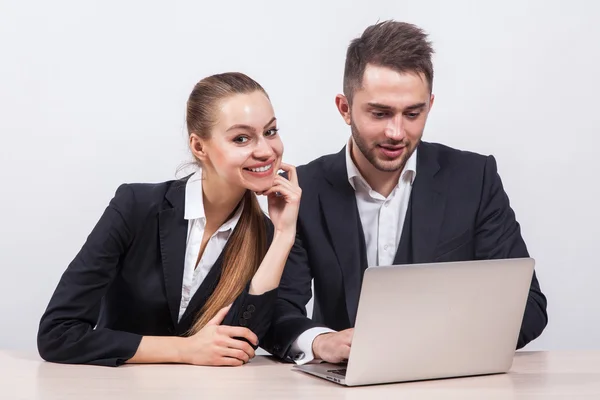 Hombre y mujer sentados en un traje de negocios en una mesa frente a — Foto de Stock