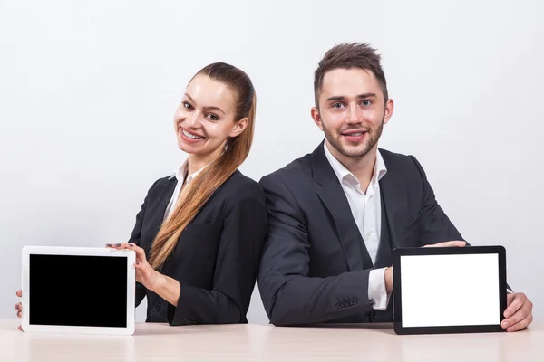 Business man and woman sitting at a table in business suits and — Stok fotoğraf