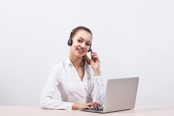 Girl in a white blouse with a headset on his head sitting in fro — Stock Photo, Image