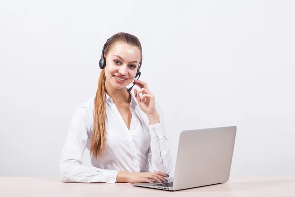 Girl in a white blouse with a headset on his head sitting in fro — Stock Photo, Image