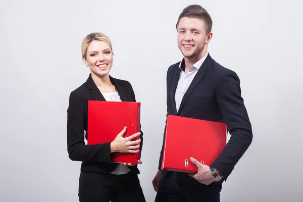 Dois homens de negócios o homem e mulher com pastas de escritório vermelhas em um w — Fotografia de Stock
