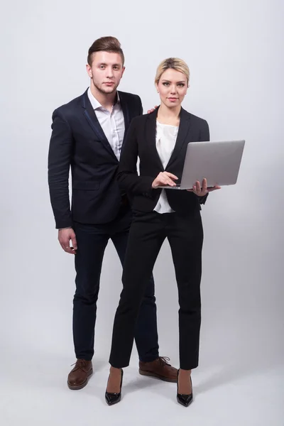 Dois homens de negócios o homem e mulher com um laptop na mão em um whi — Fotografia de Stock