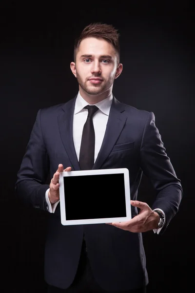 Exitoso joven hombre de negocios en un elegante traje de negocios en un bla — Foto de Stock