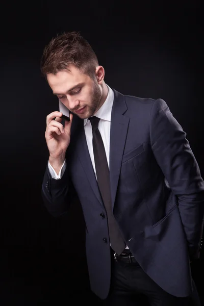 Κομψά, μοντέρνα επιχειρηματία σε ένα επαγγελματικό κοστούμι σε ένα μαύρο έκφραση — Φωτογραφία Αρχείου