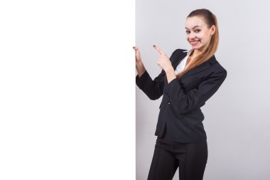 girl in a business suit stands next to the board for the text an