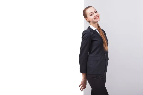 Girl in a business suit stands next to the board for the text an — Stockfoto