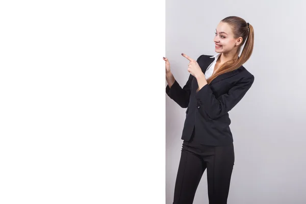Girl in a business suit stands next to the board for the text an — Φωτογραφία Αρχείου