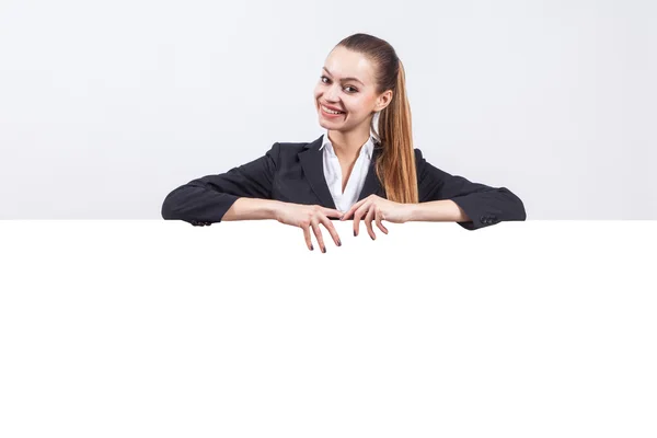 Studio portrait on white background successful woman in a business suit that stands next to the board to advertise where your text will — Φωτογραφία Αρχείου