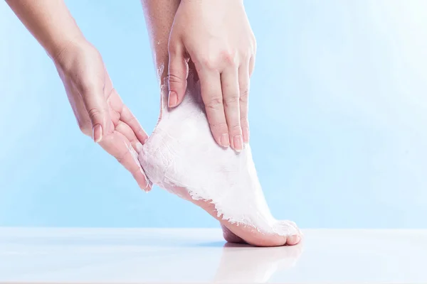 Woman lubricates the parched skin and well-groomed feet and heel — Stock Photo, Image