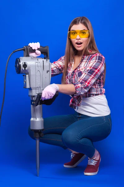 Sexy brunette in a yellow building with glasses and a plaid shir — ストック写真