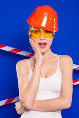 inşaat kask ve mavi bir arka plan üzerine gözlük ile sarışın