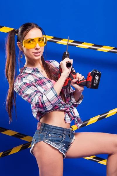 Seksowny brunetka dziewczynka pracownik budowlany z śrubokręt na blu — Zdjęcie stockowe