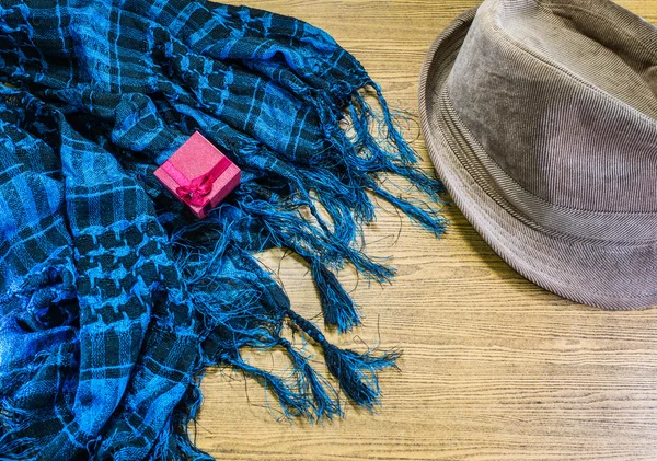 Roter Geschenkkarton, Schal und Mütze auf Holz. — Stockfoto