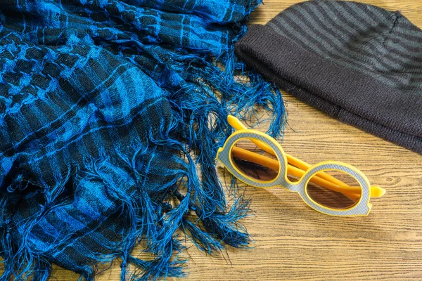 Bufanda, gafas de sol y sombrero de invierno en madera . —  Fotos de Stock