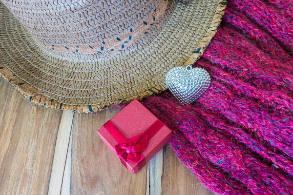 Подарочная коробка, серебряное сердце, шарф, шляпа на деревянном фоне — стоковое фото