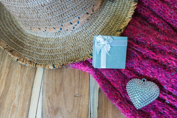Caja de regalo, corazón de plata, bufanda, sombrero sobre fondo de madera decorat — Foto de Stock
