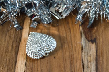 Ahşap zemin üzerinde gümüş kalp.