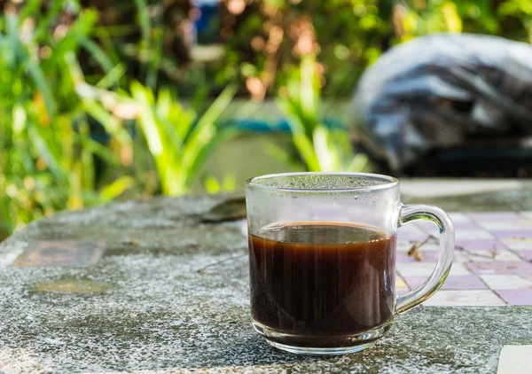 Xícara de café preto na mesa de pedra e fundo folha verde — Fotografia de Stock