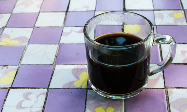 Xícara de café preto em um padrão quadrada xadrez . — Fotografia de Stock