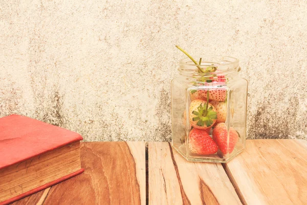 Pot de fraises et un livre sur un bois, couleur de processus avec Vintag — Photo