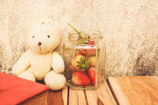 Erdbeerglas und Teddybär auf einem hölzernen, verarbeitbaren Farbtupfer mit vi — Stockfoto
