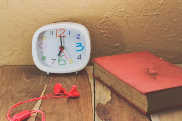 Clock earphone and a book on wooden. Process color with vintage — Stock Photo, Image