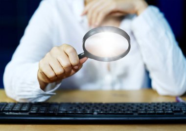 Parlayan büyüteçle bilgisayar ekipmanlarını inceleyen işadamı İnternet Bilgi Güvenliği Konsepti büyüteç üzerine odaklanmayı seçin.