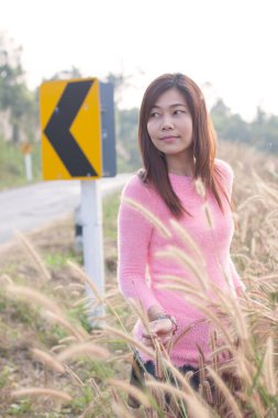 Çayırdaki güzel kız doğanın tadını çıkarıyor. Gün batımında neşeli bir kadın. Yaşam tarzı ve mutluluk kavramı