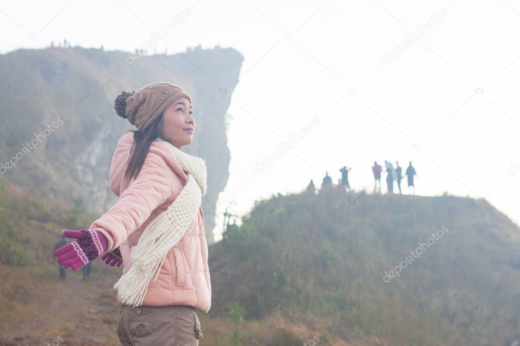 Young woman enjoying the view on the Phu Chi Fa Viewpoint, Chiang Rai, Thailand , foggy spring landscape