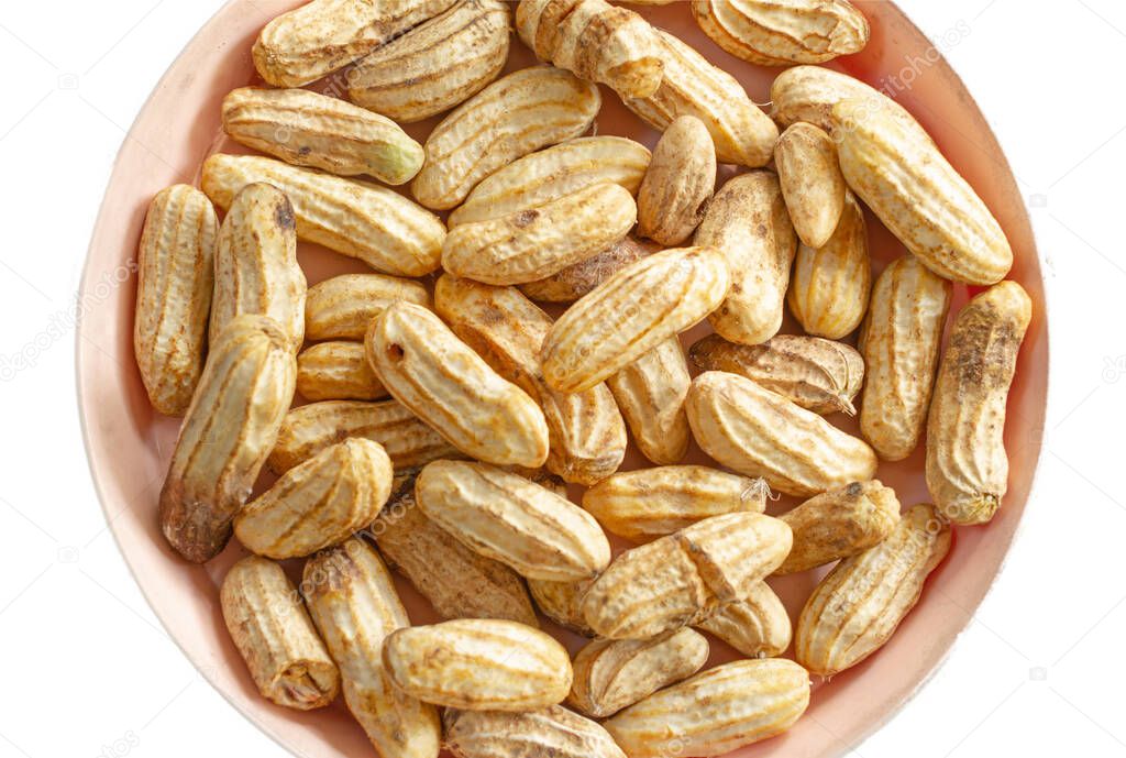 Closeup of dried peanuts in bowl isolated on white background.